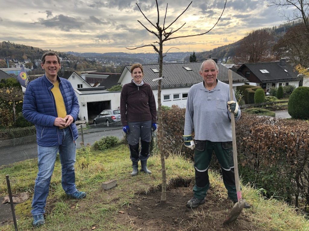 Das Foto zeigt Jens Kamieth (MdL), Verena Pittke und Achim Hölgers (Projektleiter der TG FRIESEN) beim Pflanzen eines Apfelbaumes